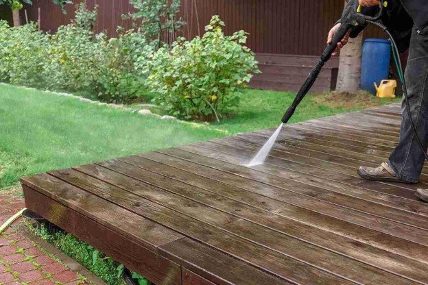 Professional pressure washing a weathered wood deck to remove dirt, buildup, and surface stains in Rowlett, TX
